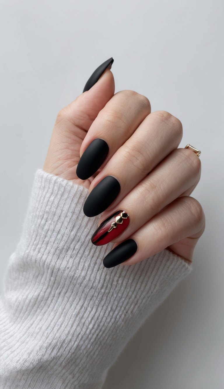 Matte black nails paired with a glossy red chrome accent and gold studs, creating a dramatic emo-glam look.