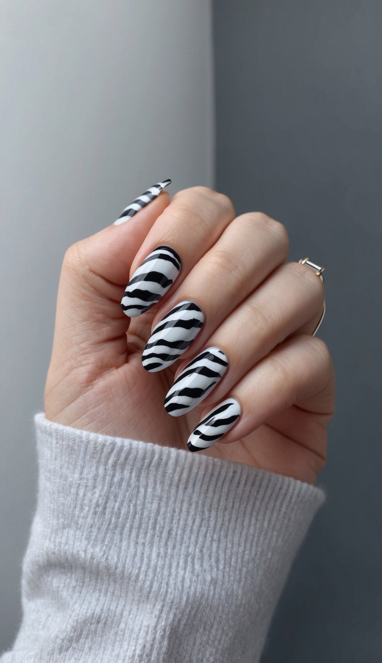 Matte black and white zebra-striped nails with an edgy, hand-painted finish for a bold emo look.