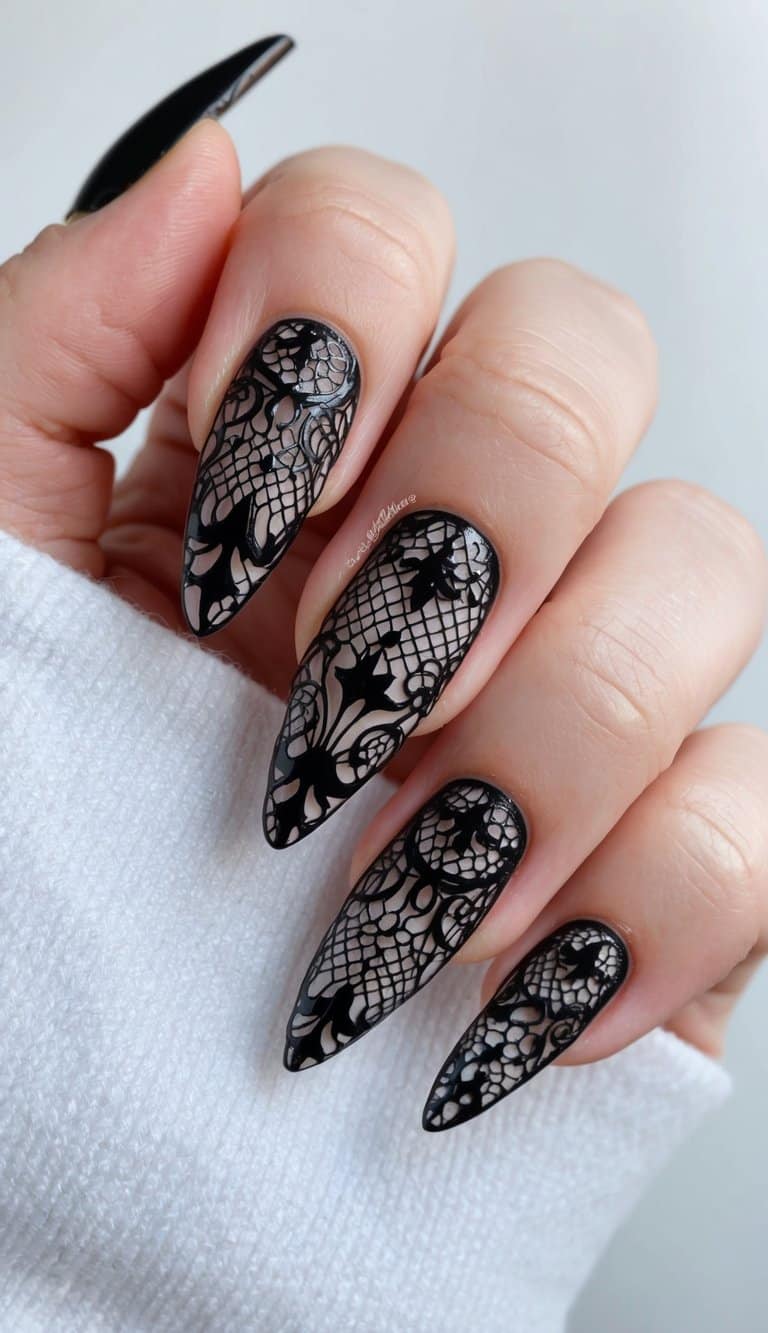 A close-up of gothic black lace nail art on a white background, with intricate and playful designs