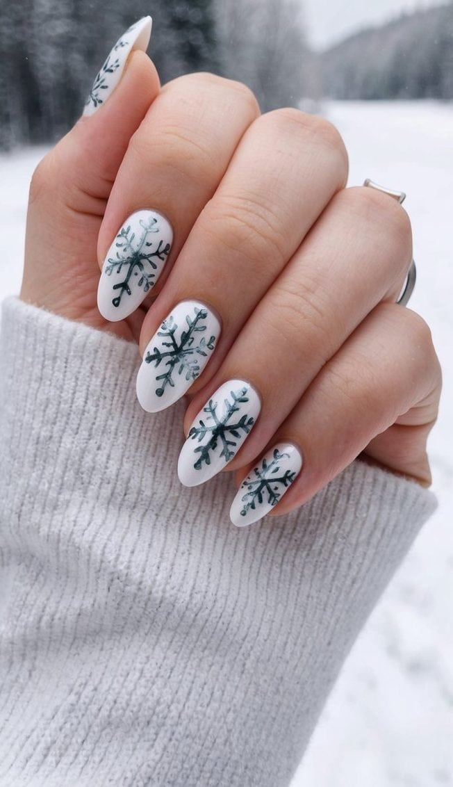 A close-up of nails adorned with intricate Nordic snowflake designs, set against a wintery backdrop
