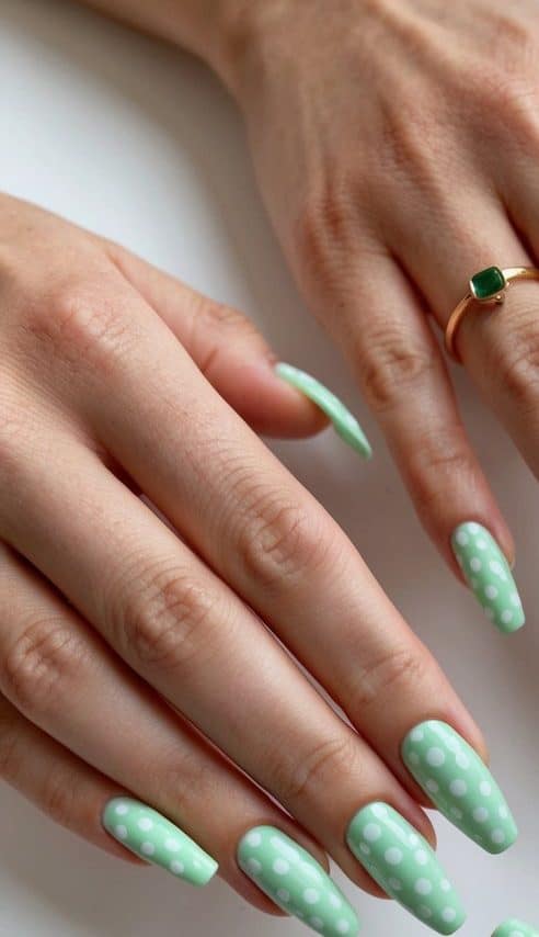 A collection of mint green nails with white polka dots arranged in a fresh and vibrant display