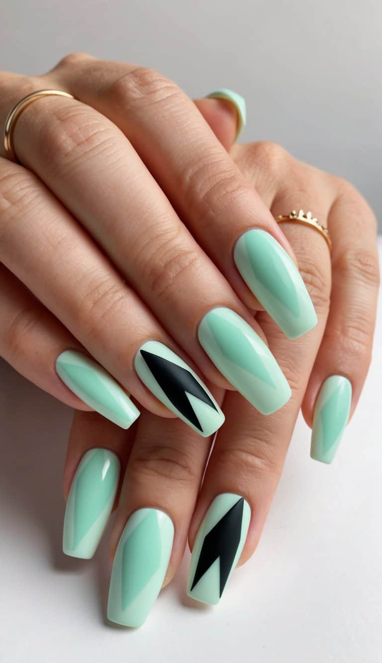 A mint green geometric nail art design with black accents