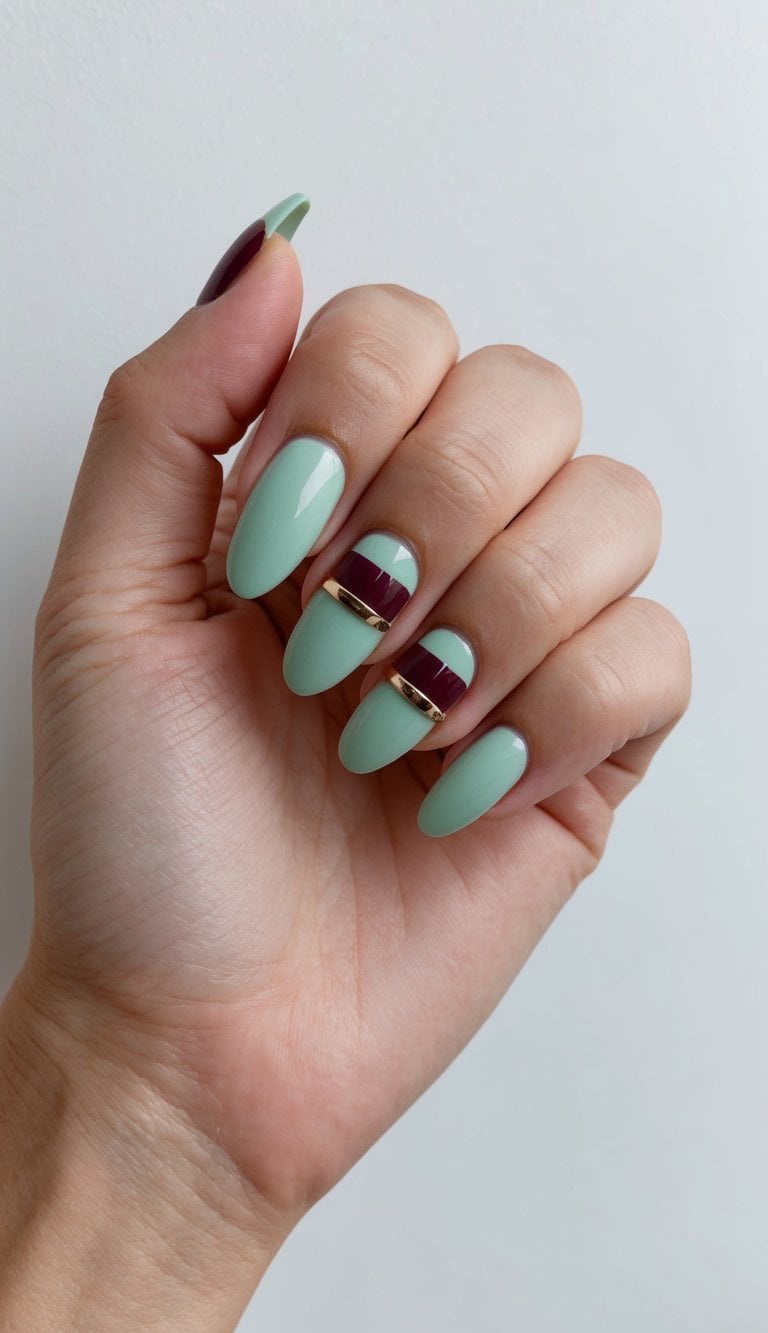 A chic, mint green nail art design with burgundy accents on a clean, white background