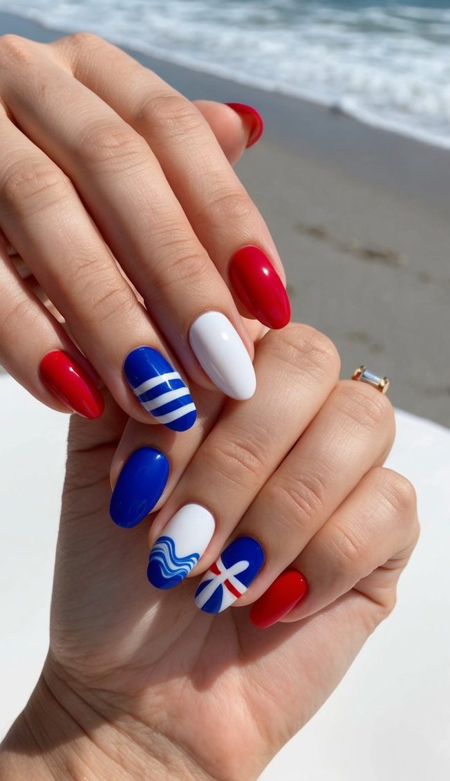 A beach scene with red, white, and blue nail art designs on a table with ocean waves in the background