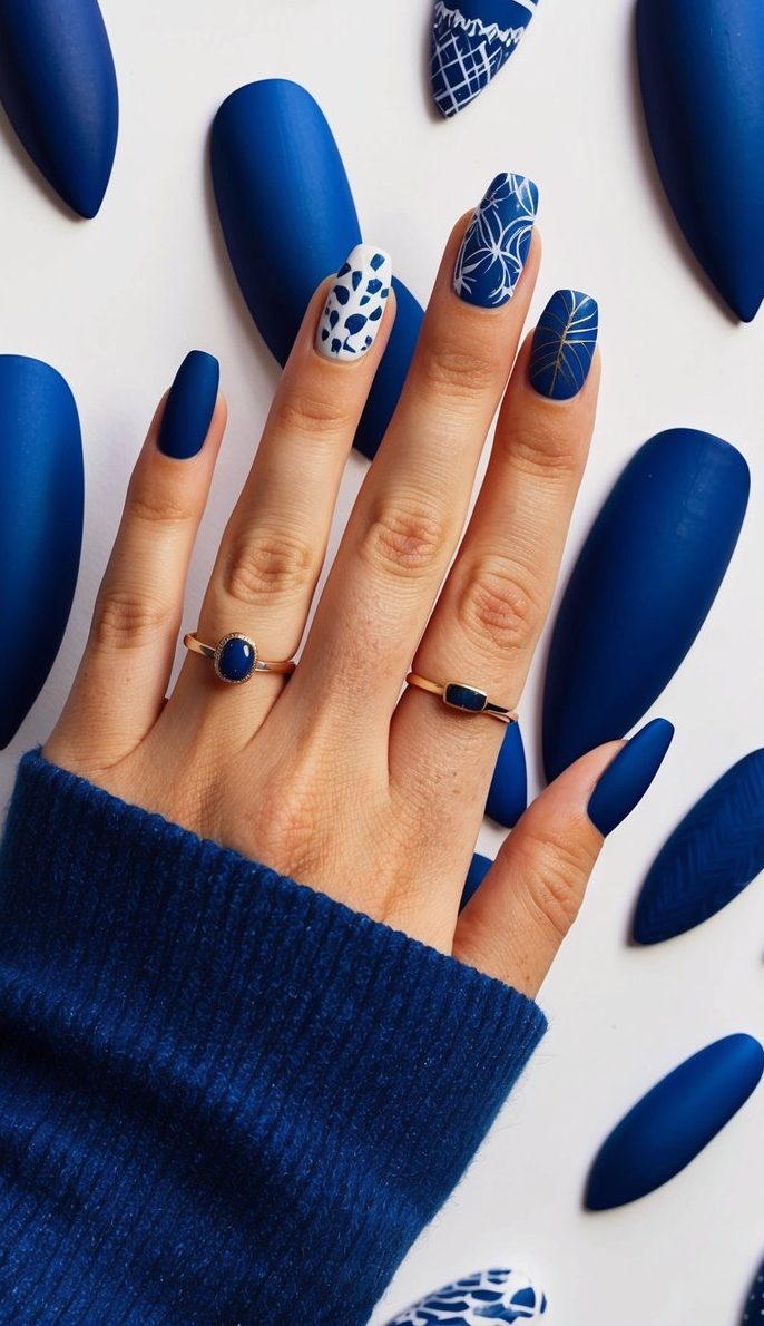 A collection of 50 blue matte nail art designs displayed on a white background, showcasing various patterns and styles