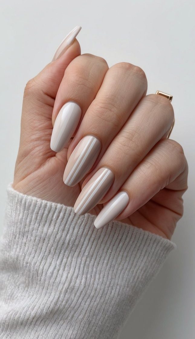 A clean, minimalist nail design with sleek lines and geometric shapes in a neutral color palette