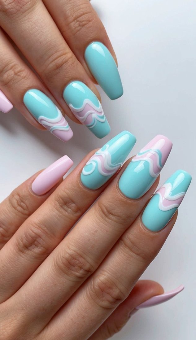 A pastel-colored nail art design featuring waves and swirls, with a baby shower theme