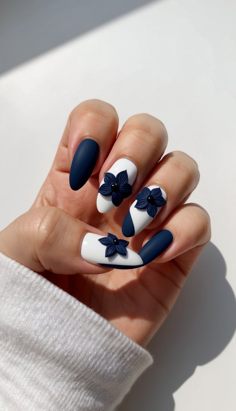 A navy floral nail art design with 3D elements on a clean, manicured nail
