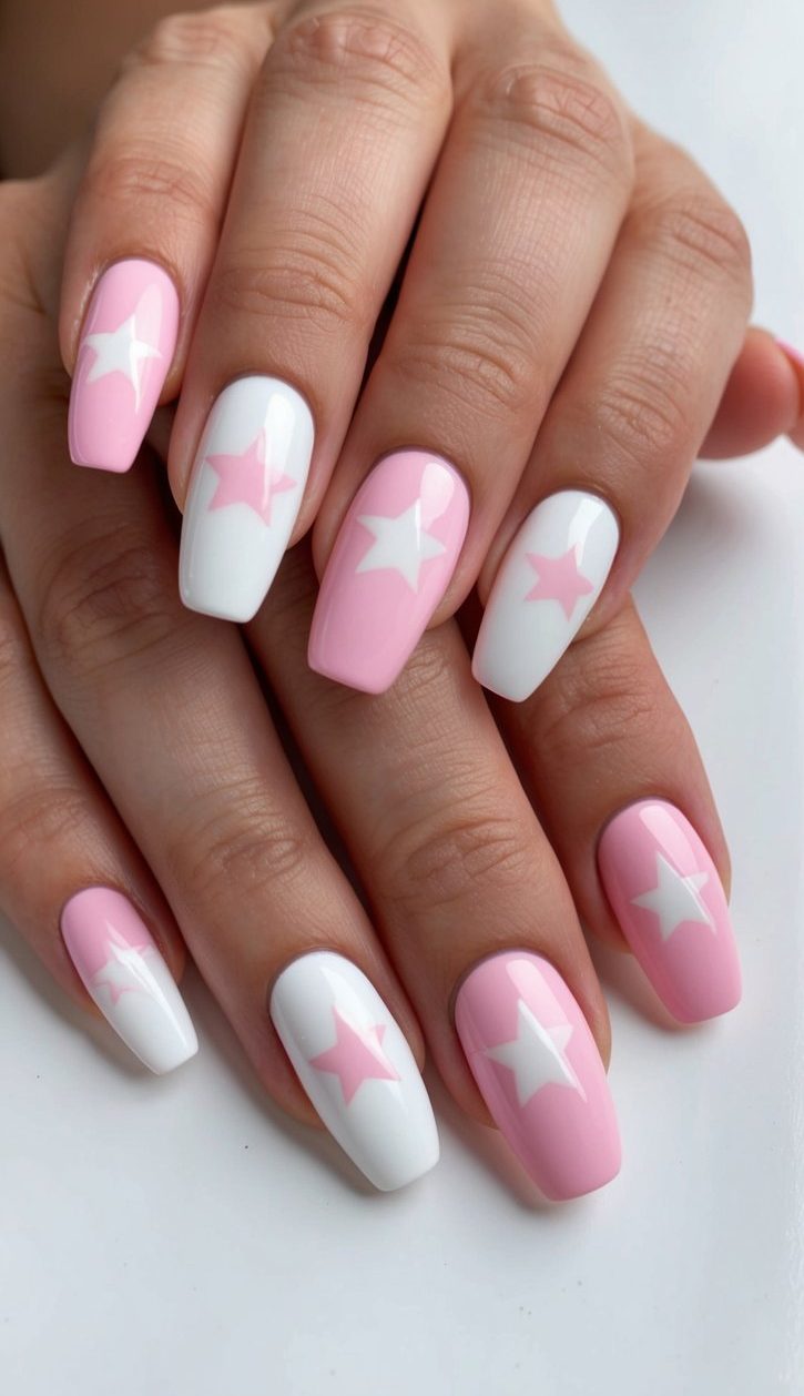 A close-up of pink and white nails with star designs