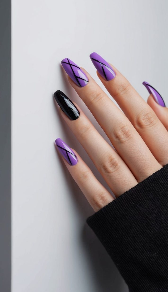 A close-up of purple and black geometric nail art on a sleek, modern surface