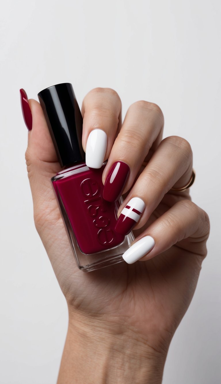 A hand with ruby-red and white French tips holding a nail polish bottle