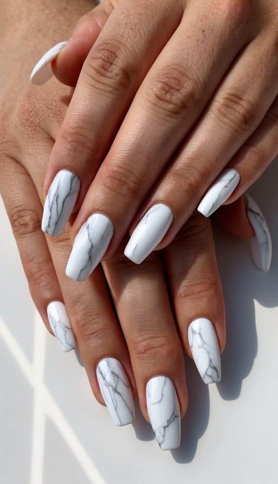 A set of 50 white marble effect nail art designs displayed on a clean, minimalist backdrop
