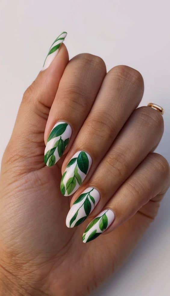 A hand with perfectly manicured nails adorned with leafy green print