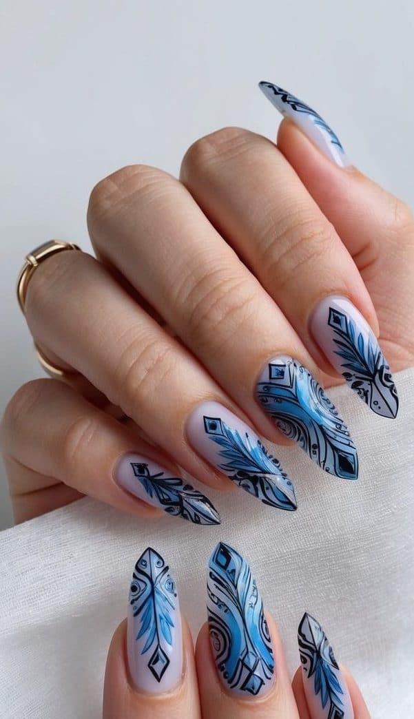 A regal ice-themed nail art design with intricate black and blue patterns on a clean, manicured surface