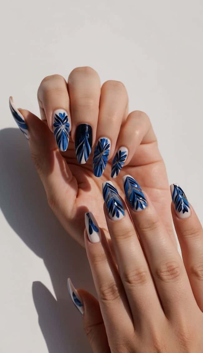 A sleek and sophisticated nail art display featuring intricate black and blue designs on a clean, minimalist background