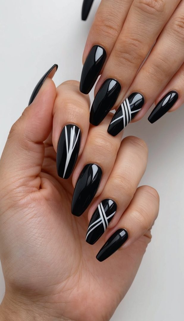 A sleek black geometric nail art design with bold lines and edgy patterns