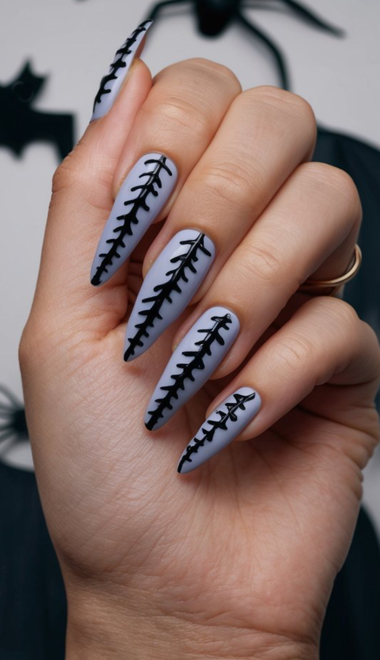 Matte nails in a muted light purple hue get a creepy-cute vibe from bold, black stitch designs down the center