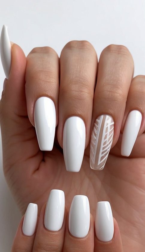 Smooth white nails with one nude-toned accent etched in crisp white lines resembling foliage, giving a refined modern edge to a clean manicure.
