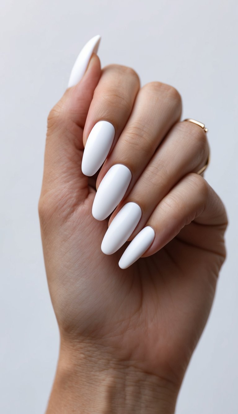 Hand with clean almond-shaped white nails in a matte finish, showcasing a minimalist and classic manicure style.