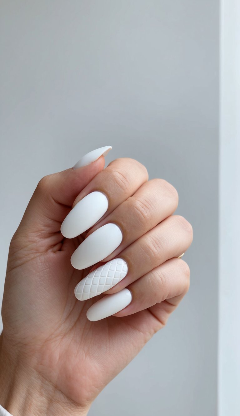 Close-up of matte white nails featuring a quilted texture on the ring finger for a subtle, elegant contrast.
