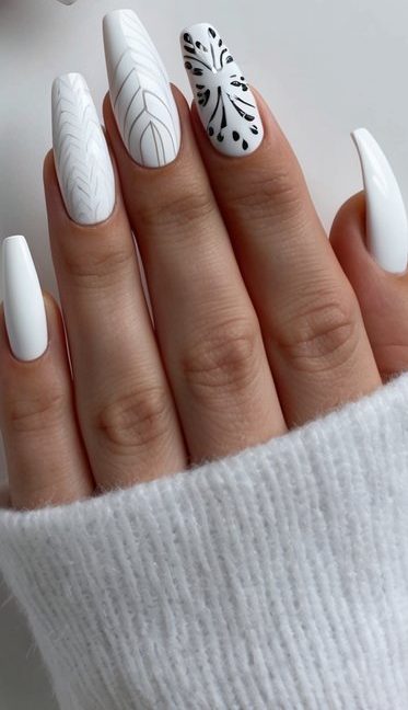 White nails with thin black leaf and botanical-inspired line art, combining clean design with modern monochrome style.