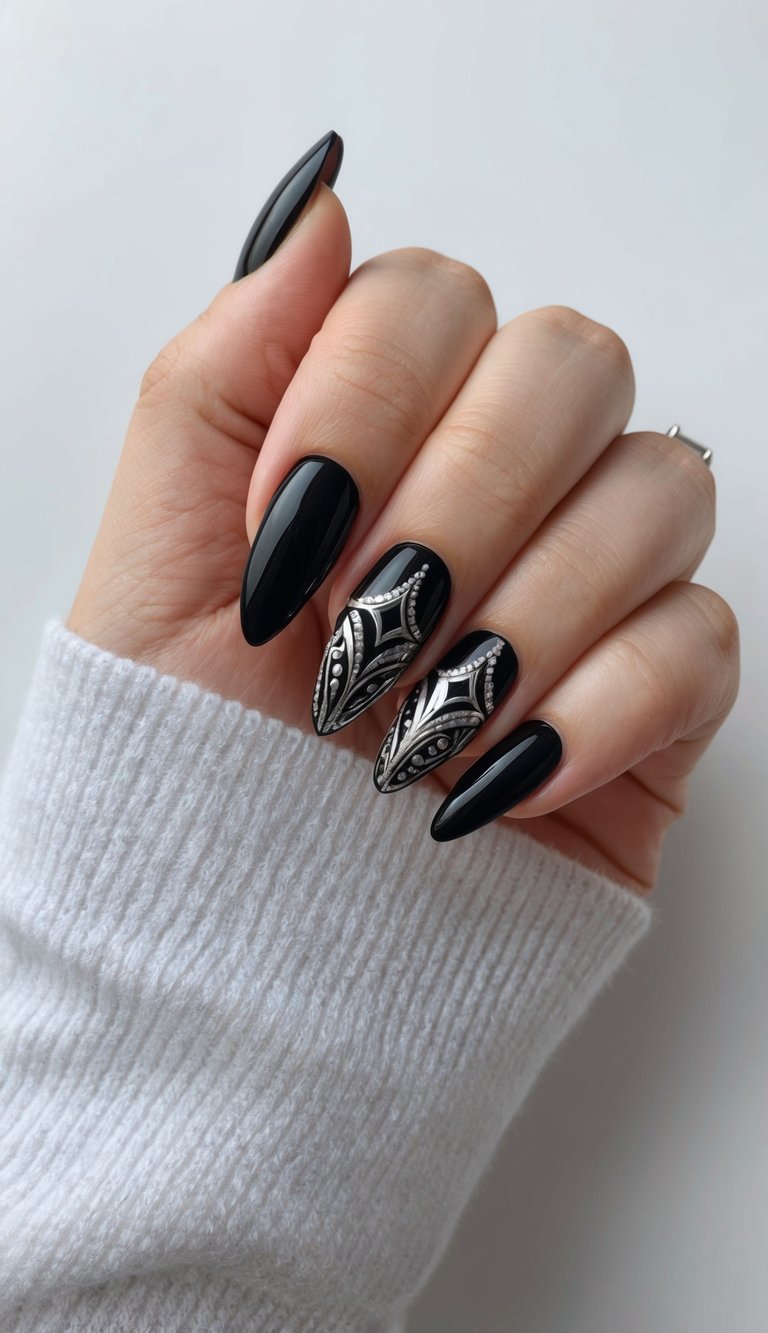 Close-up of almond-shaped nails featuring high-shine black polish and silver art deco-style embellishments on the middle fingers.