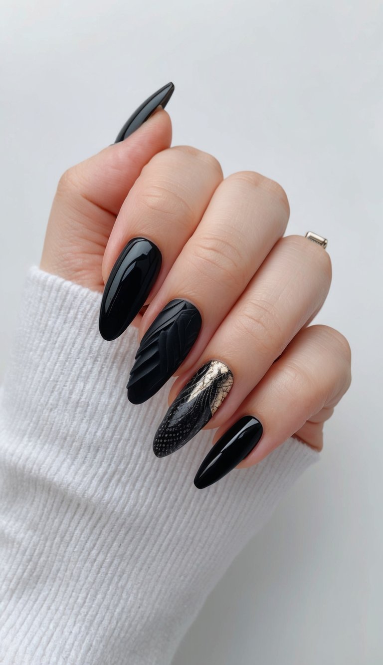 Black nails with a sculptural raised pattern on the ring finger and a shimmering gold crackle accent on the middle nail.
