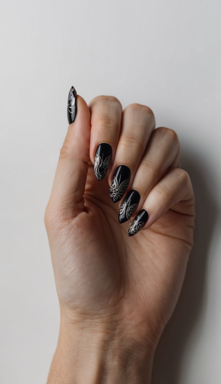 Black almond-shaped nails with ornate silver filigree details elegantly curling from the tips.