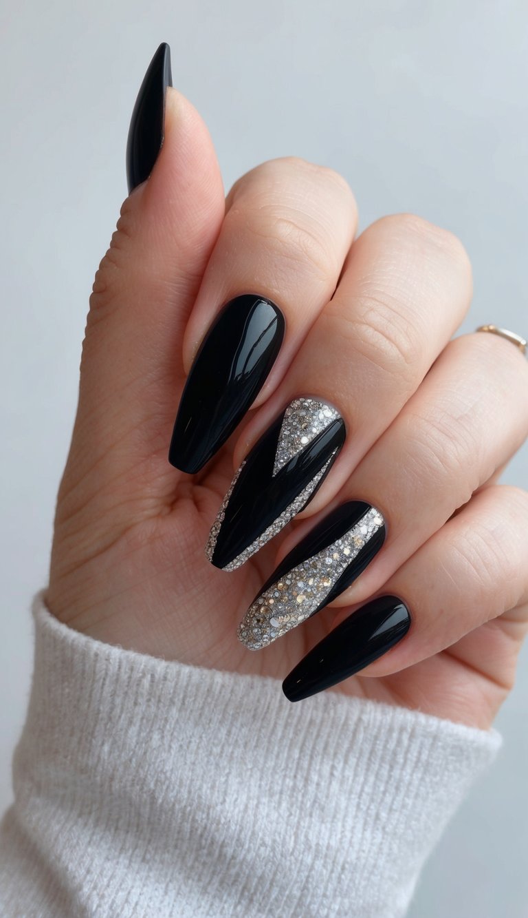 Glossy black almond nails with bold silver rhinestone inlays forming sleek geometric accents.
