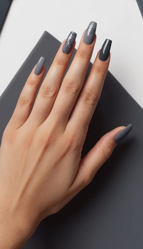 Edgy charcoal gray nail design with long tips and silver plant-like accents for a fierce, standout style.