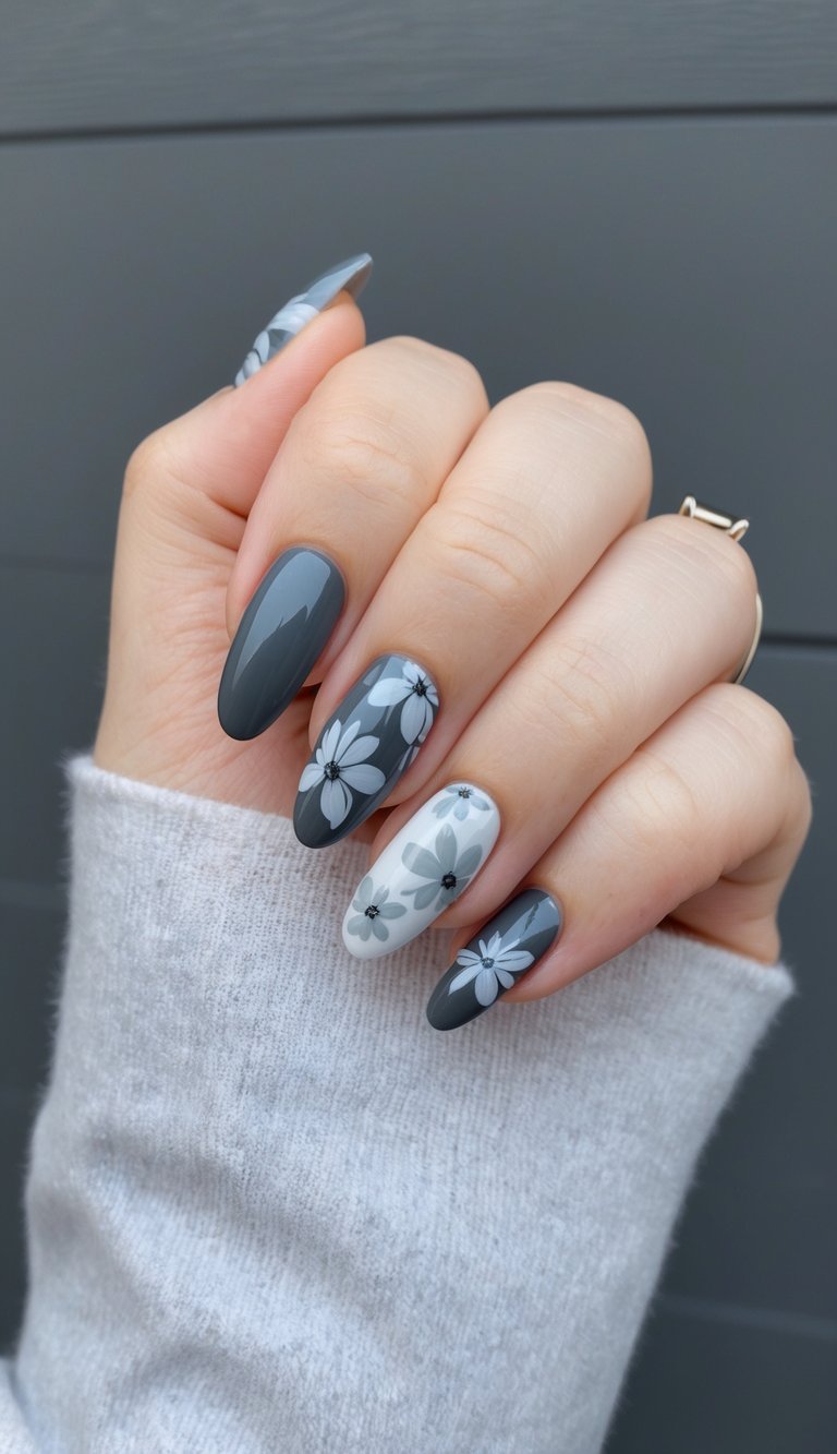 Gray and white daisy-patterned nails on a charcoal base, blending moody tones with soft floral detailing.