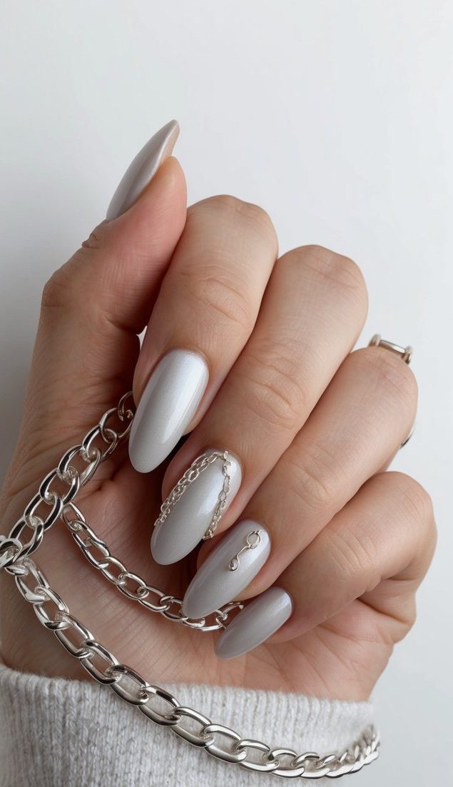 Shimmering silver chains draped over sleek nail art designs