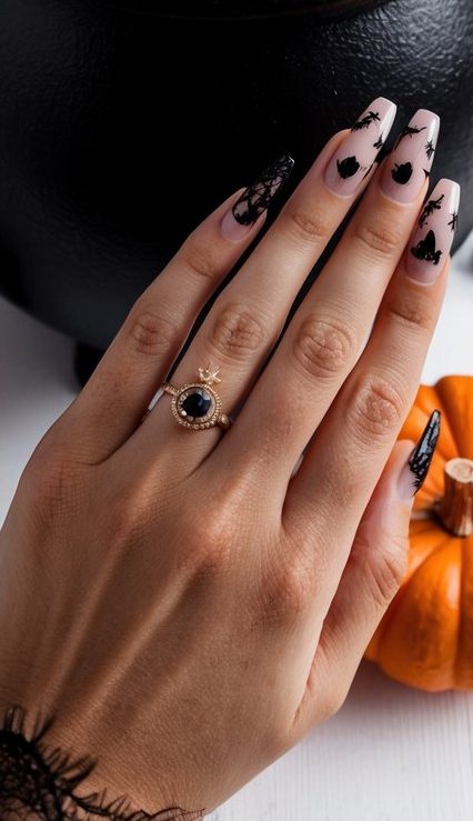 Soft nude Halloween nails with subtle black moons, bats, and web details, designed in a sleek coffin shape for dark glamour.
