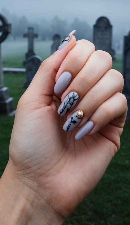 Pale grey nails with thin black branches and tiny bat silhouettes, styled for a calm and ghostly Halloween vibe.