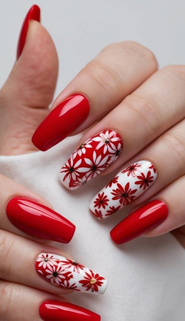 Red and white nails featuring detailed daisy-style floral patterns with layered petals and dark centers for a bold botanical design.