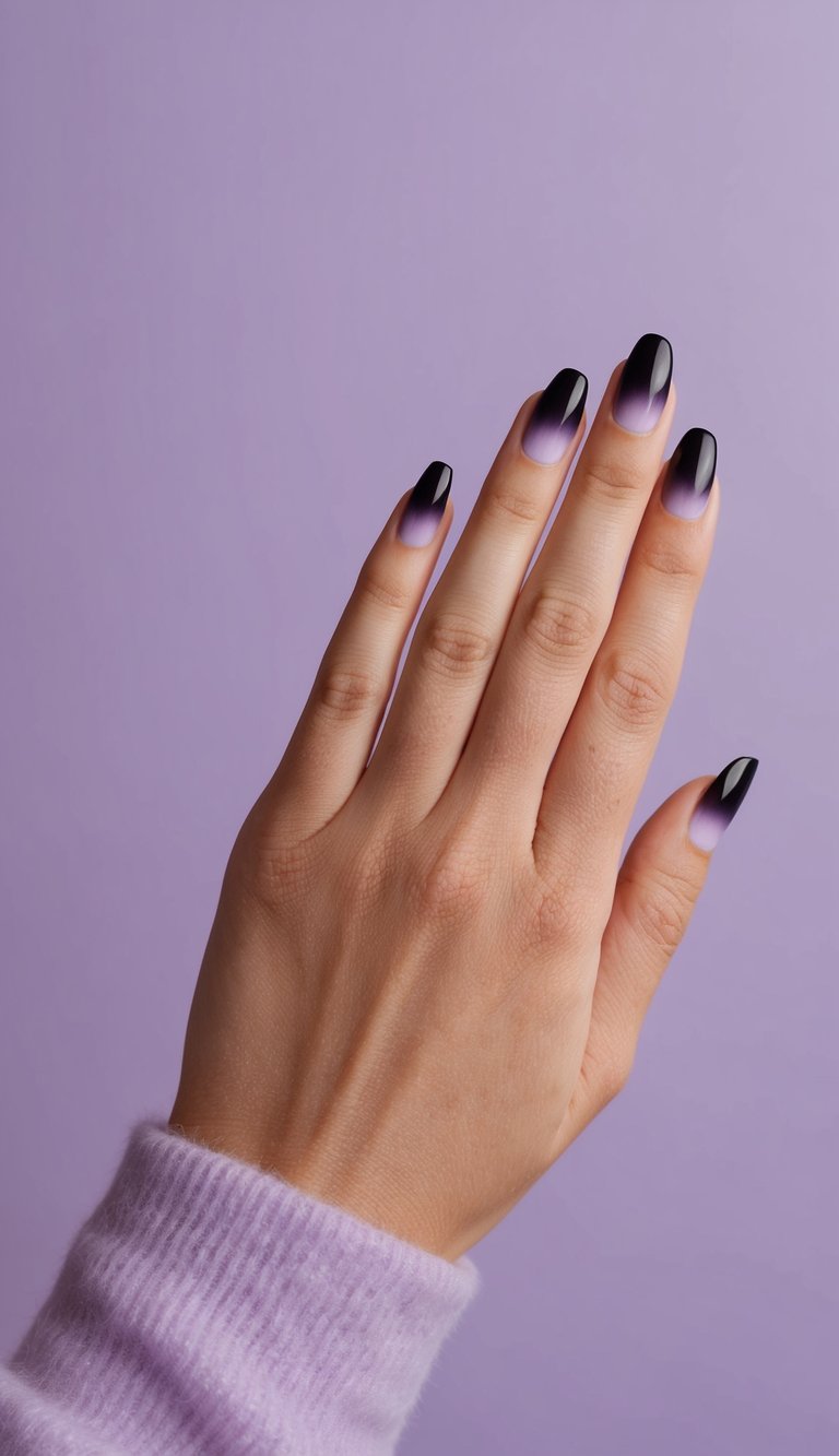 Close-up of a hand with almond-shaped nails fading from glossy black to soft lavender, styled against a muted purple background.