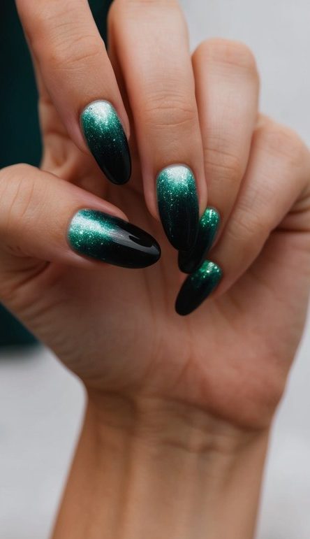 A close-up of black ombre nails with a shimmering emerald glow, set against a dark, enchanting backdrop