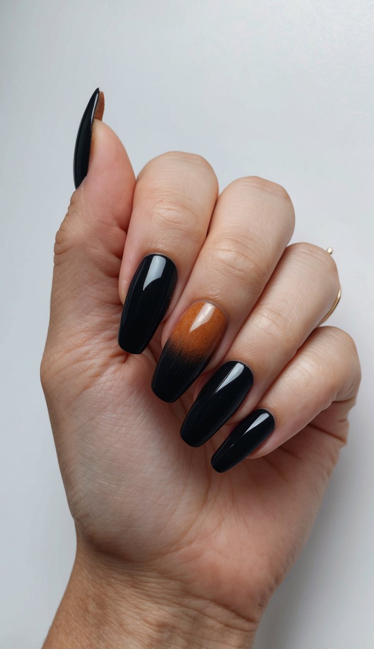 Hand with long, glossy black nails and one accent nail featuring a soft ombré blend from warm amber to black on a clean white background.