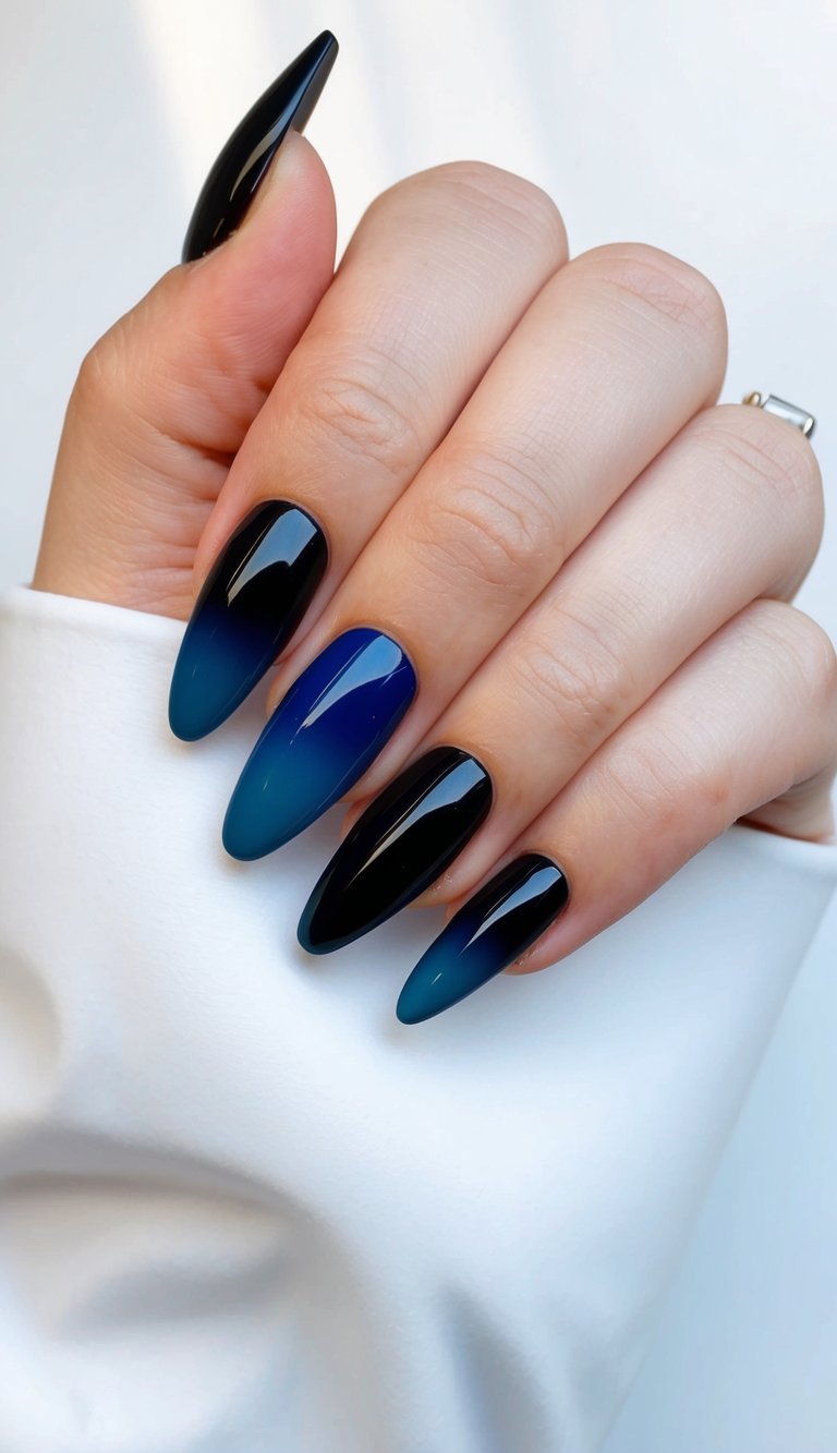 Glossy ombré nails fading from black to cobalt blue, arranged in a gentle grip pose against a bright, clean background.