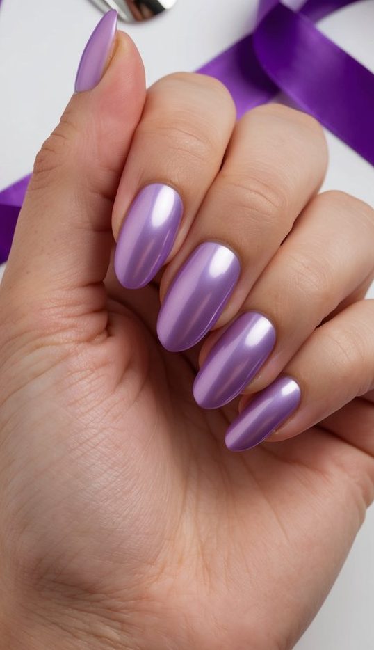Close-up of almond nails in a silky lavender chrome finish with a pearl-like reflection and soft metallic glow.
