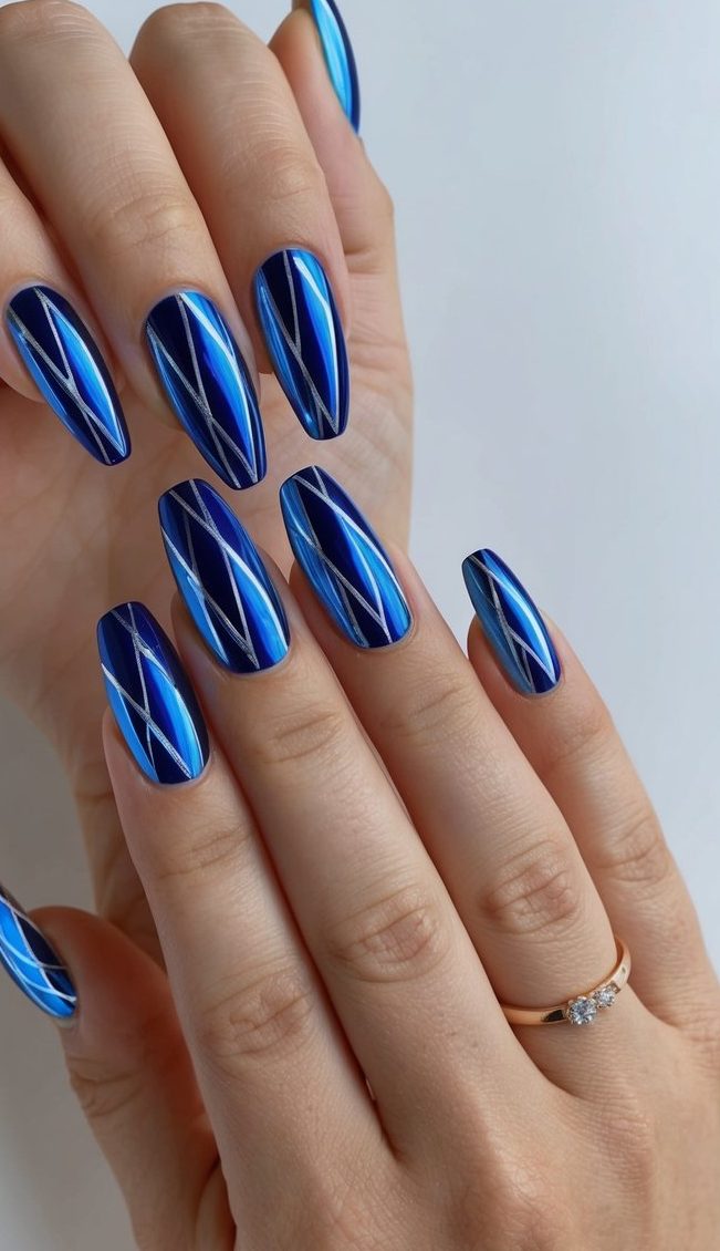 A close-up of blue chrome geometric patterns on nails