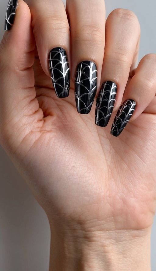 A spider web-inspired black chrome nail art design on a sleek, modern background