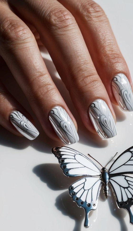 A white chrome butterfly with intricate wing patterns resting on a sleek white surface