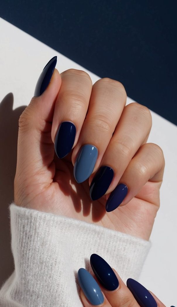 A collection of polished gemstones in varying shades of navy blue, set against a dark midnight backdrop