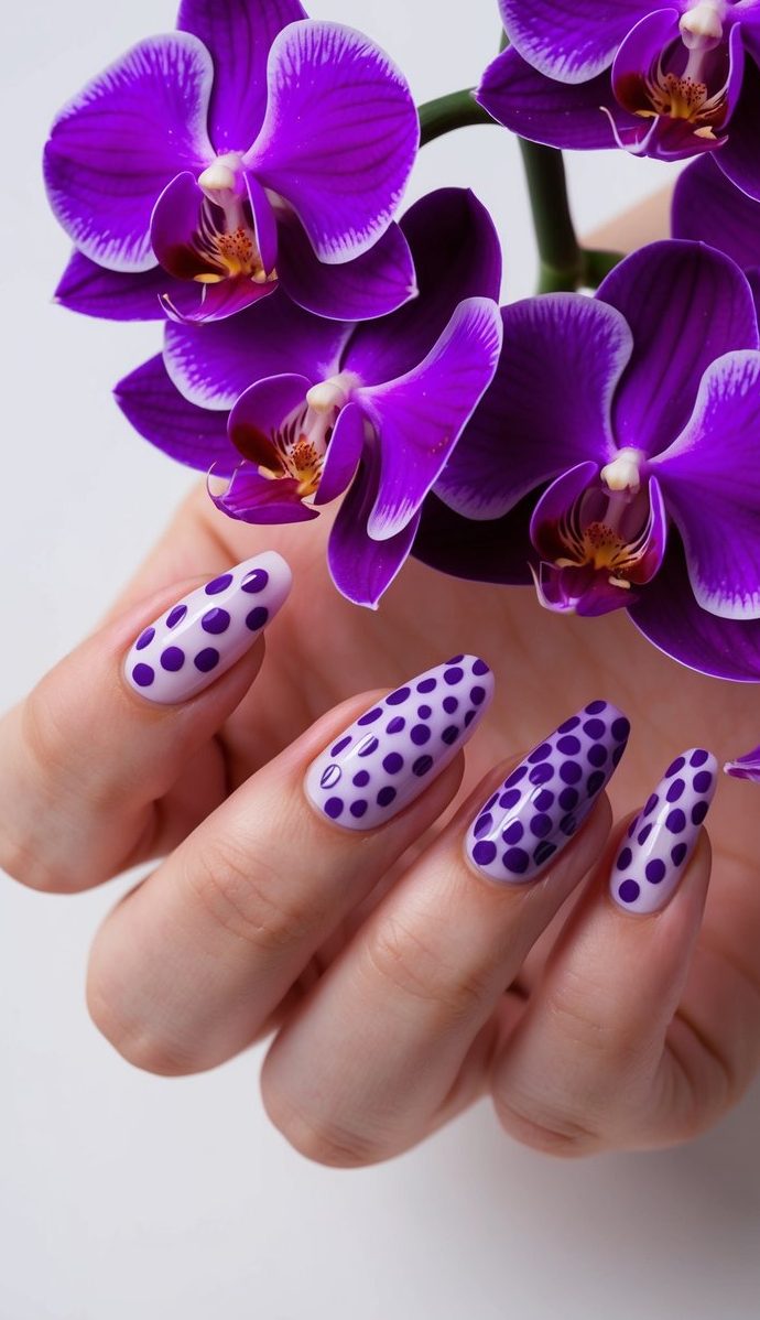 A close-up of various purple orchid petals arranged in a dot pattern, with different shades of purple creating a vibrant and artistic nail art design