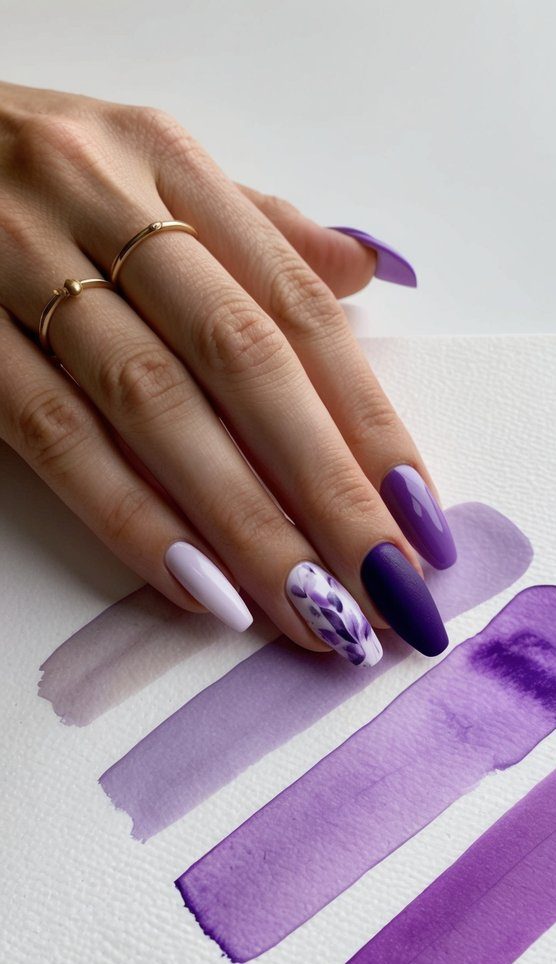 A palette of various shades of purple watercolor washes spread across a white canvas, showcasing different nail art designs