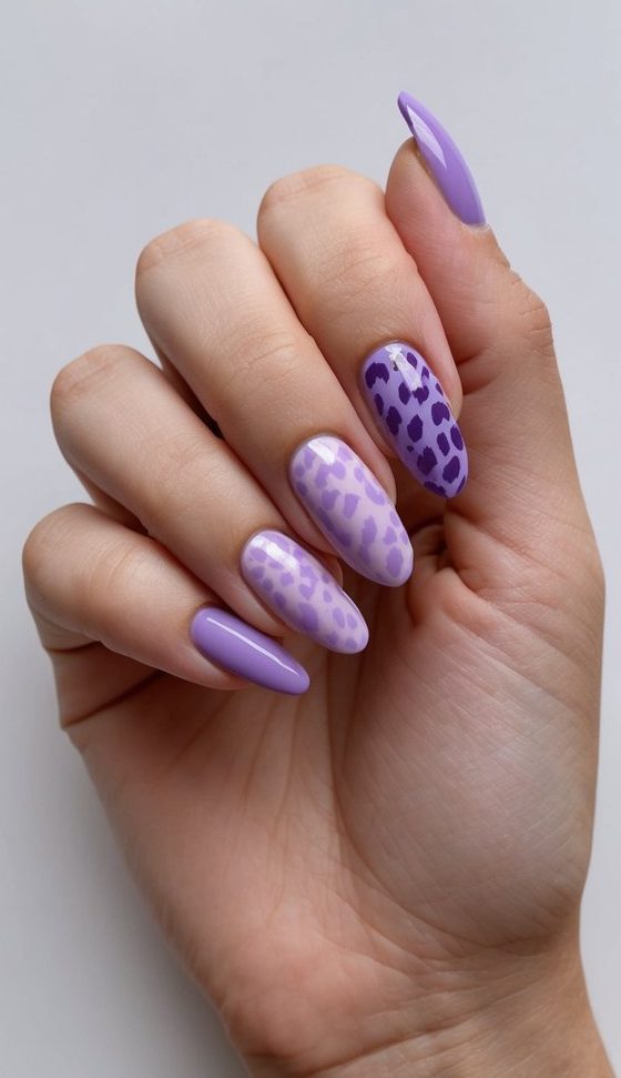 A lavender leopard print nail art design with various shades of purple on a clean, manicured surface