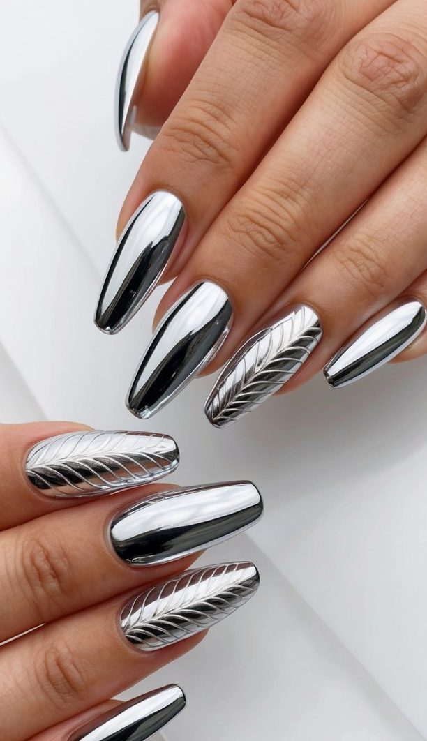 Two hands displaying coffin-shaped chrome nails with alternating textured silver design pattern creating dimensional metallic manicure.