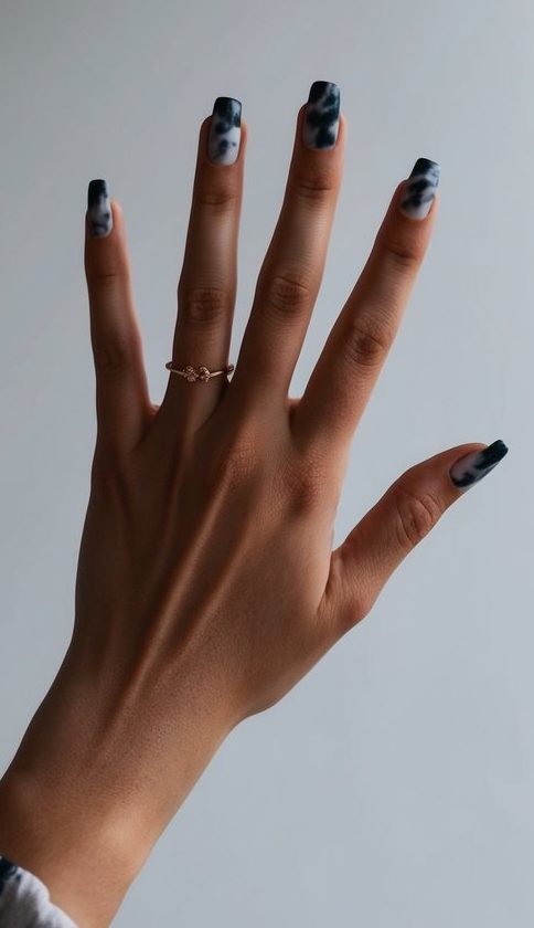 Matte black and gray swirl nails with a smoky, clouded effect for a subtle emo-inspired vibe.