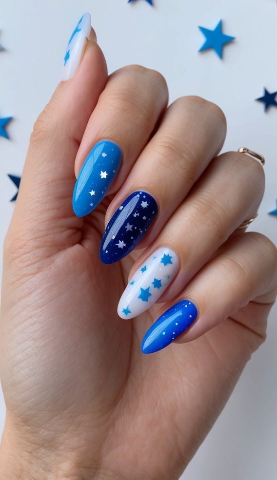 Bright blue, navy, and white nails with playful star designs—perfect for a bold January-inspired manicure.